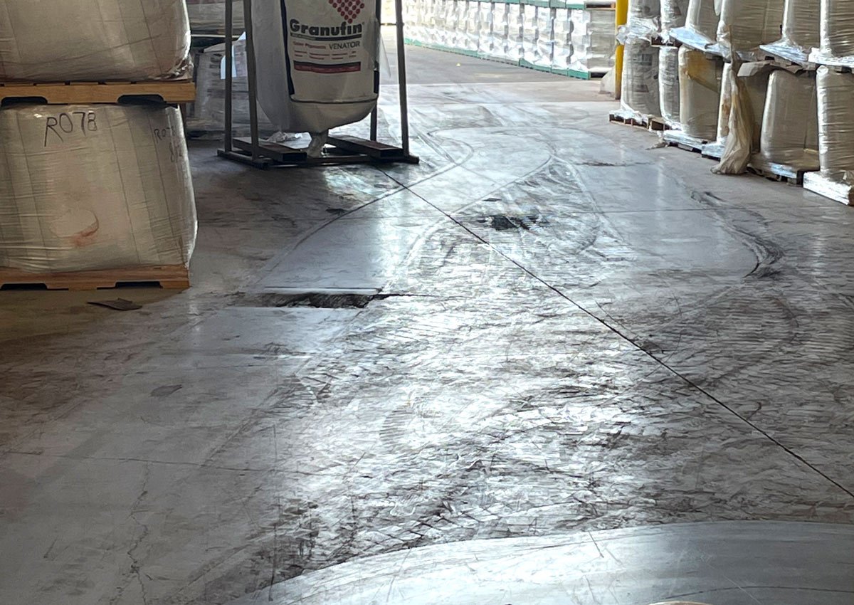 Photograph of dirty floor in large facility.